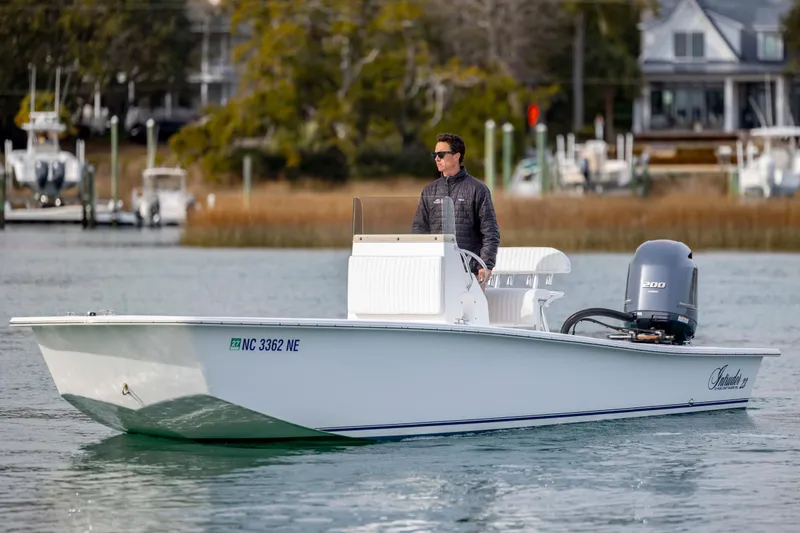 Slide: The Image of 2025 Intruder 23 boat cruising on water with driver, featuring sleek design and powerful engine. - 9