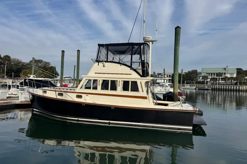 The Image of 2001 Ellis 36 Flybridge boat docked in a marina under a clear sky. - 1