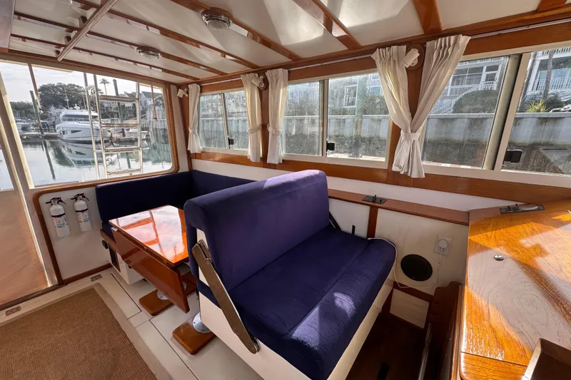 Slide: The Image of Interior of 2001 Ellis 36 Flybridge boat with blue seating and wooden table. - 10