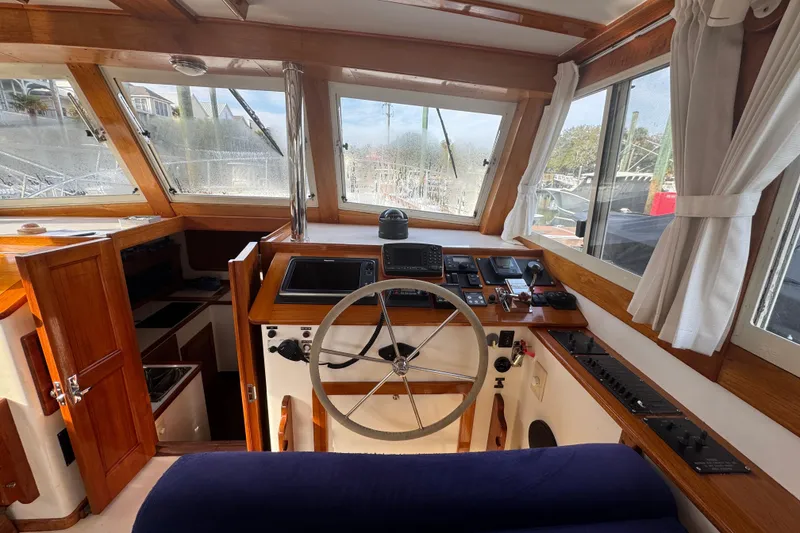 Slide: The Image of Interior helm of 2001 Ellis 36 Flybridge boat with wooden accents and navigation equipment. - 11