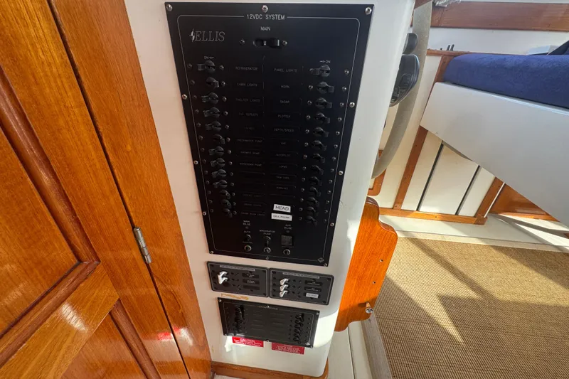 Slide: The Image of Control panel of a 2001 Ellis 36 Flybridge boat, featuring switches and wooden interior. - 14