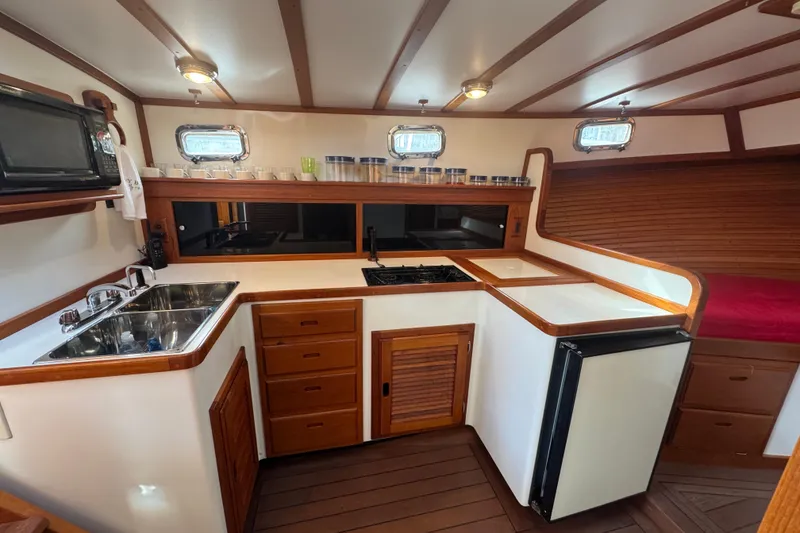Slide: The Image of 2001 Ellis 36 Flybridge yacht kitchen with wooden cabinetry, sink, stove, and refrigerator. - 17