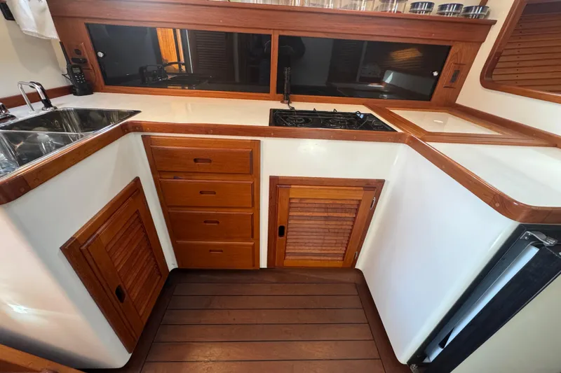 Slide: The Image of Galley kitchen in 2001 Ellis 36 Flybridge boat with wood cabinetry and dual sink. - 19