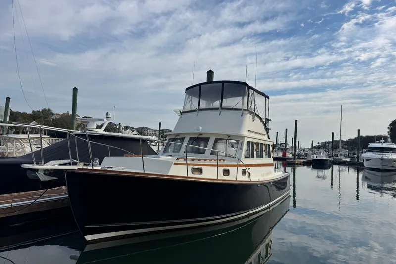Slide: The Image of 2001 Ellis 36 Flybridge boat docked in a marina under a partly cloudy sky. - 2