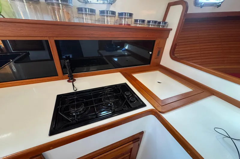 Slide: The Image of 2001 Ellis 36 Flybridge kitchen with stove, sink, and wooden cabinetry. - 22