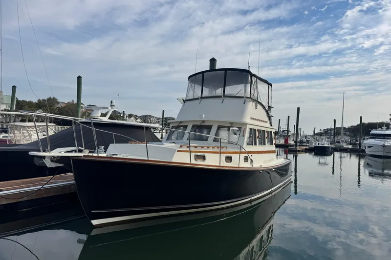 Slide: The Image of 2001 Ellis 36 Flybridge boat docked in a marina under a partly cloudy sky. - 3