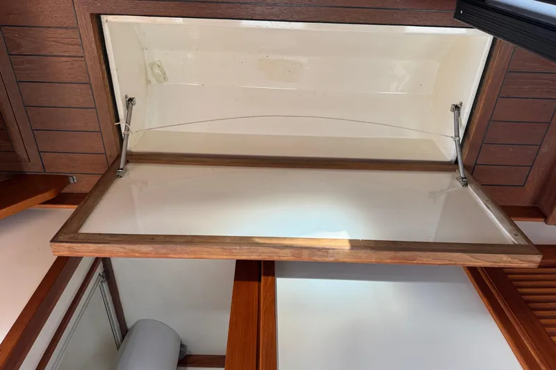 Slide: The Image of Open storage compartment on 2001 Ellis 36 Flybridge boat, featuring wooden trim and hydraulic supports. - 31