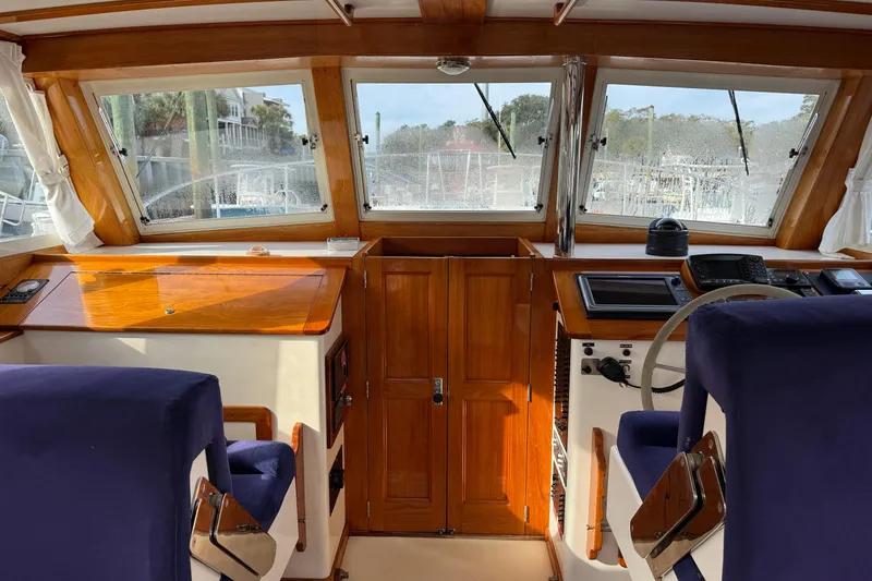 Slide: The Image of Interior view of 2001 Ellis 36 Flybridge boat with wooden dashboard and blue seats. - 32