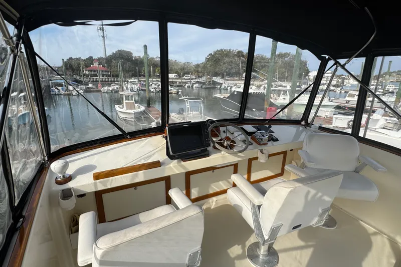 Slide: The Image of Flybridge interior of 2001 Ellis 36, featuring helm and marina view. - 38