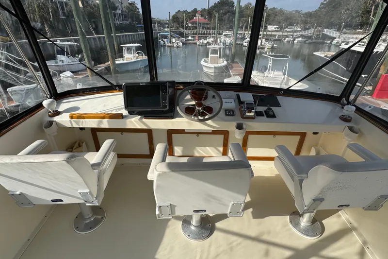 Slide: The Image of Flybridge interior of 2001 Ellis 36, featuring helm, electronics, and three white captain chairs. - 39