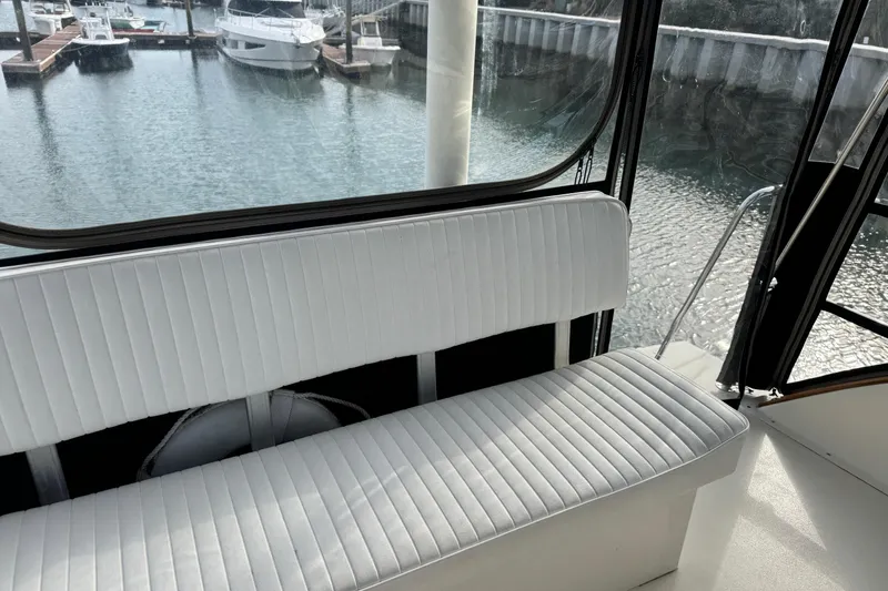 Slide: The Image of Interior view of 2001 Ellis 36 Flybridge with white seating and marina backdrop. - 41