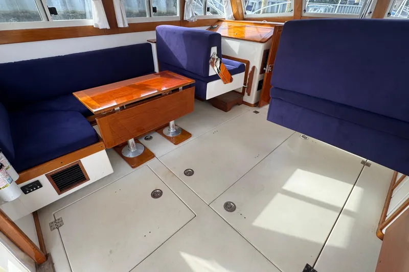 Slide: The Image of Interior of 2001 Ellis 36 Flybridge with blue seating and wooden table. - 45