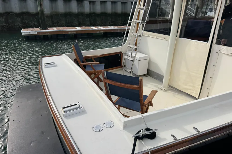 Slide: The Image of 2001 Ellis 36 Flybridge boat with chairs on deck, docked at marina. - 51
