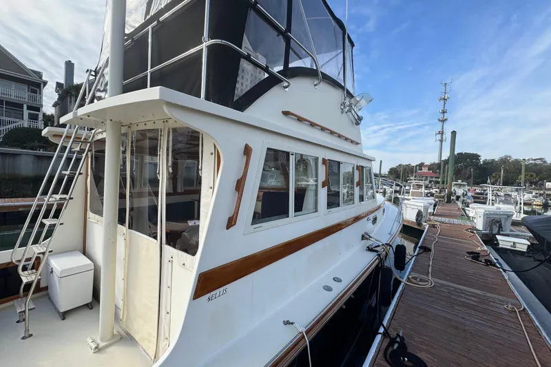 Slide: The Image of 2001 Ellis 36 Flybridge yacht docked at marina, showcasing elegant design and spacious deck. - 7