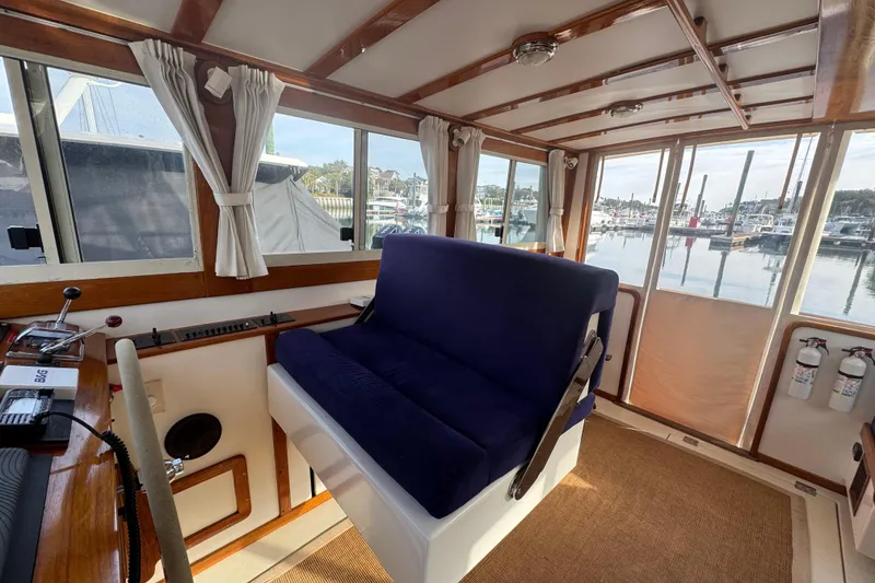 Slide: The Image of Interior of 2001 Ellis 36 Flybridge boat with blue seating and marina view. - 9