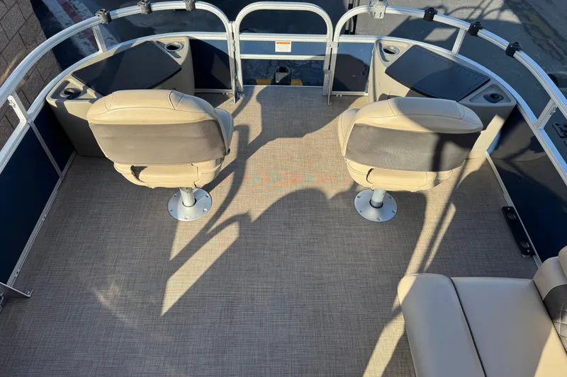 Slide: The Image of 2022 Sun Tracker Fishin' Barge 22 DLX interior with two swivel seats and carpeted floor. - 10