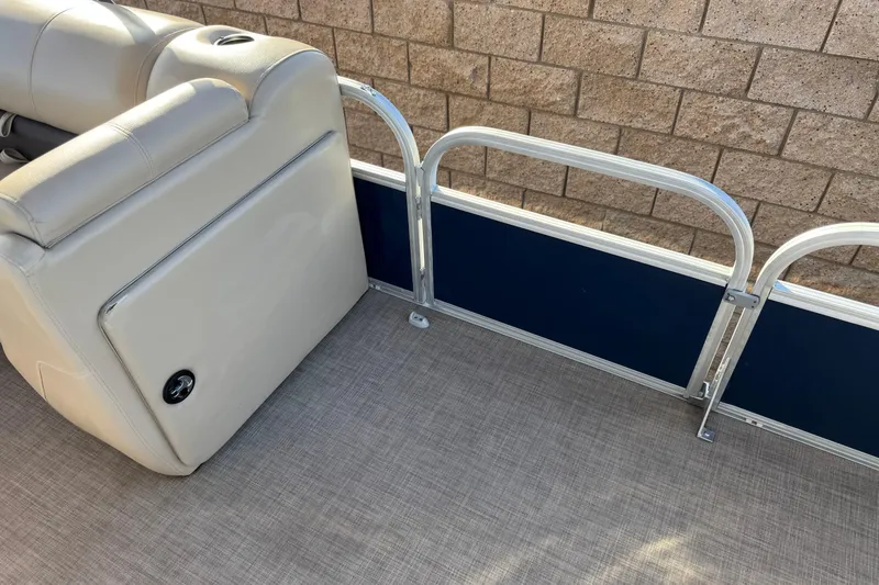 Slide: The Image of 2022 Sun Tracker Fishin' Barge 22 DLX interior with beige seating and blue paneling. - 18