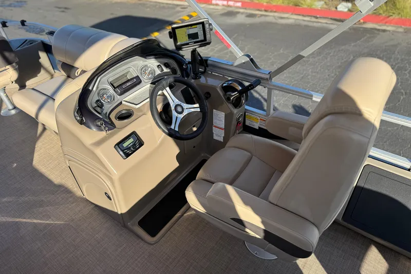 Slide: The Image of 2022 Sun Tracker Fishin' Barge 22 DLX helm with beige seating and modern controls. - 30