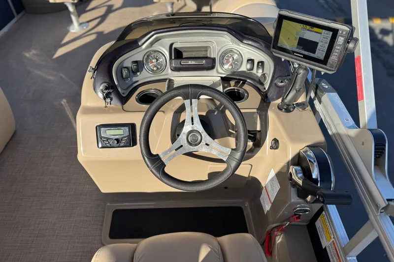 Slide: The Image of 2022 Sun Tracker Fishin' Barge 22 DLX dashboard with steering wheel and navigation system. - 31
