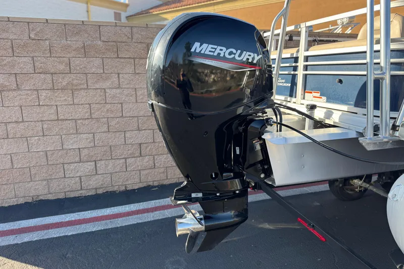 Slide: The Image of 2022 Sun Tracker Fishin' Barge 22 DLX with Mercury outboard motor, parked outdoors. - 7