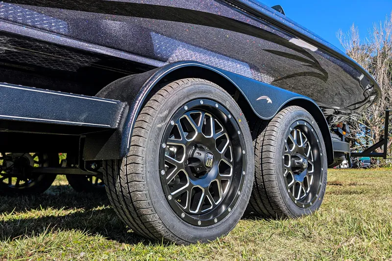 Slide: The Image of Trailer wheels of 2026 Falcon F20 PREDATOR boat on grass, showcasing sleek design. - 13