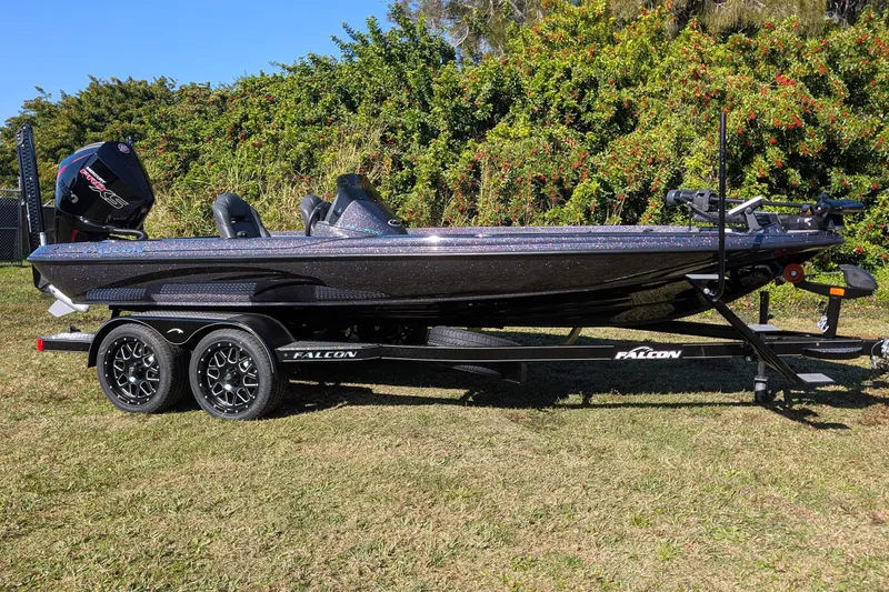 Slide: The Image of 2026 Falcon F20 PREDATOR boat on trailer, parked on grass with lush greenery background. - 6