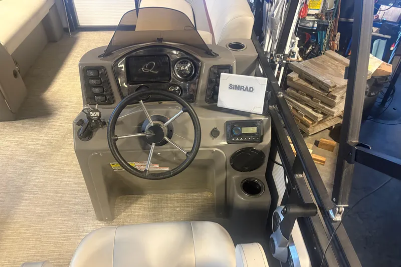 Slide: The Image of 2023 Qwest Lanai 820 boat dashboard with steering wheel and Simrad navigation system. - 10
