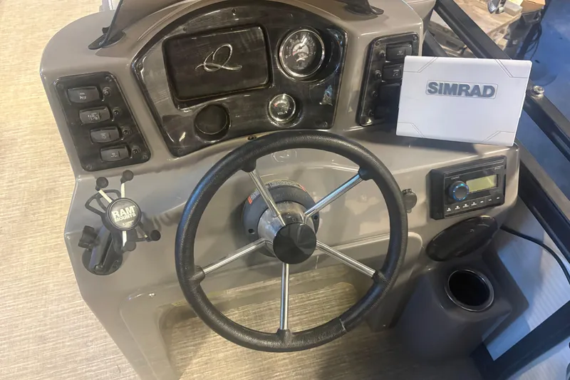 Slide: The Image of 2023 Qwest Lanai 820 boat dashboard with steering wheel, Simrad display, and control panel. - 11
