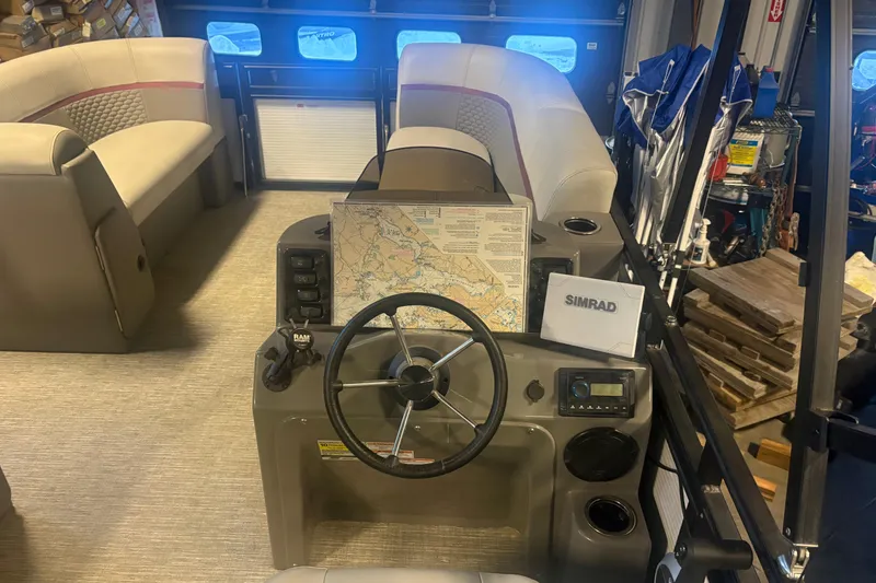 Slide: The Image of 2023 Qwest Lanai 820 boat interior with steering wheel, navigation map, and seating. - 13
