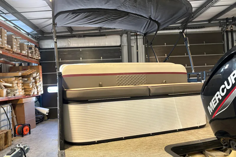 Slide: The Image of 2023 Qwest Lanai 820 pontoon boat in garage, featuring Mercury engine. - 3