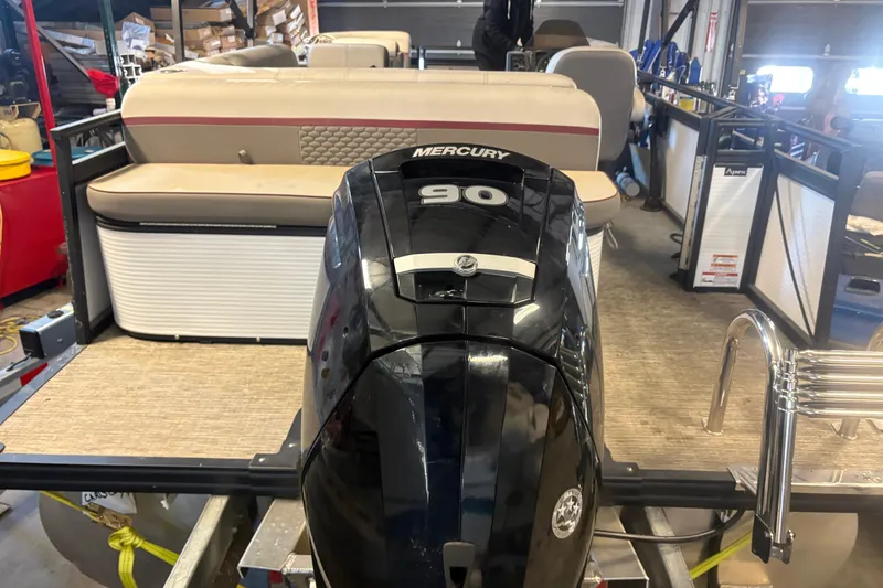 Slide: The Image of 2023 Qwest Lanai 820 pontoon boat with Mercury 90 engine in a garage setting. - 4