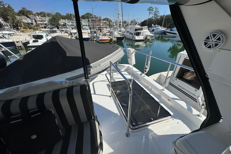 Slide: The Image of 2003 Altima 55 Pilothouse yacht docked in a marina with scenic surroundings. - 10