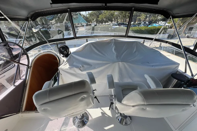 Slide: The Image of 2003 Altima 55 Pilothouse interior with covered controls and dual captain chairs. - 13