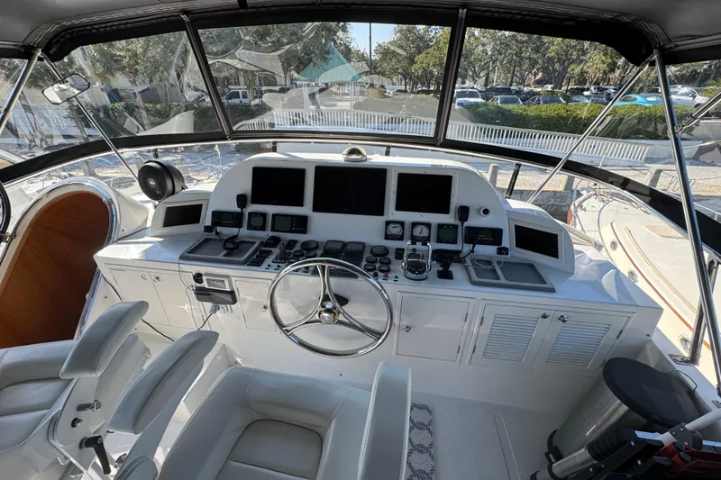 Slide: The Image of Pilothouse of 2003 Altima 55, featuring navigation controls and seating, with marina view. - 14