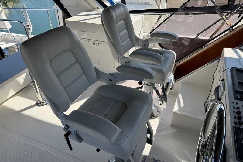 Slide: The Image of 2003 Altima 55 Pilothouse yacht deck with striped seating and wooden table. - 21