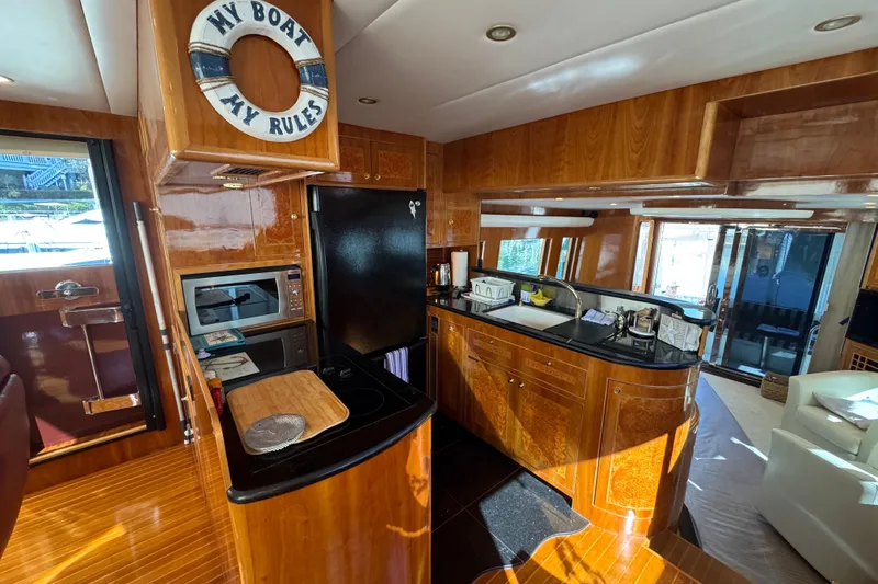 Slide: The Image of Luxurious 2003 Altima 55 Pilothouse interior with elegant dining setup and navigation controls. - 30