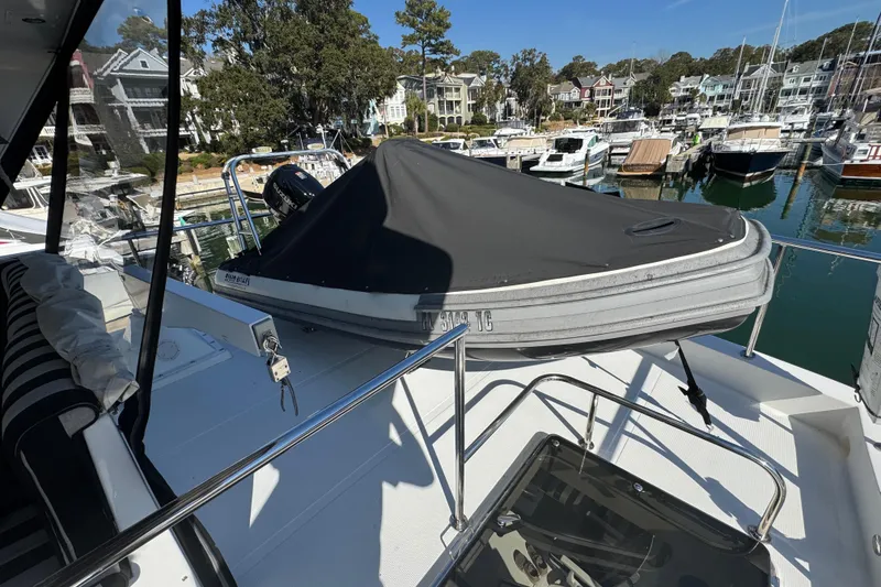 Slide: The Image of 2003 Altima 55 Pilothouse yacht with covered dinghy on deck, docked in a marina. - 8