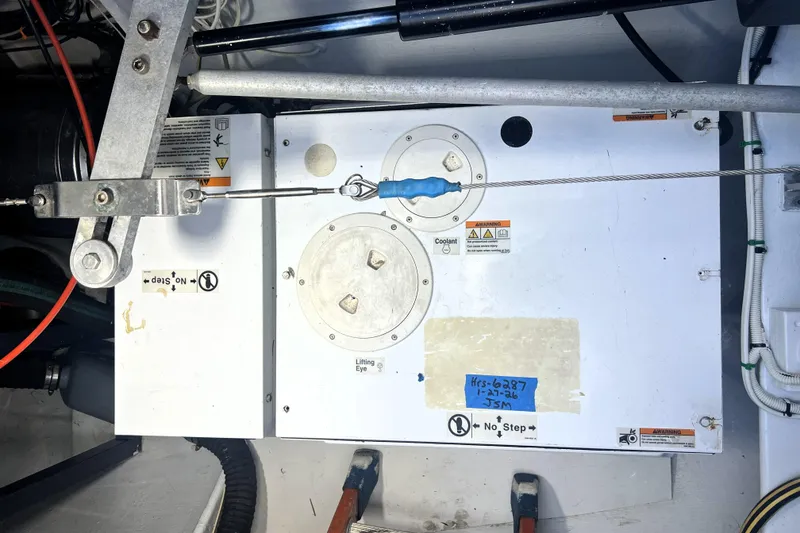 Slide: The Image of Engine compartment of 2011 Privilege 495 yacht, showing mechanical components and warning labels. - 105