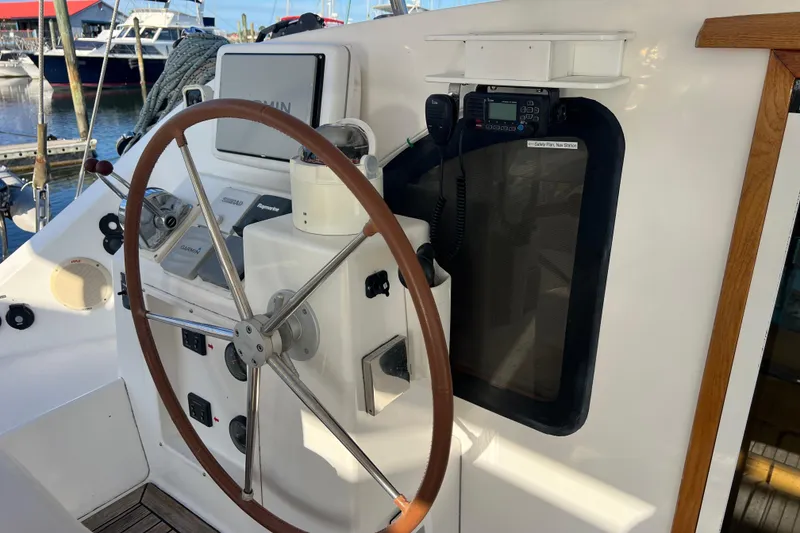Slide: The Image of Steering wheel and controls of a 2011 Privilege 495 yacht at a marina. - 12