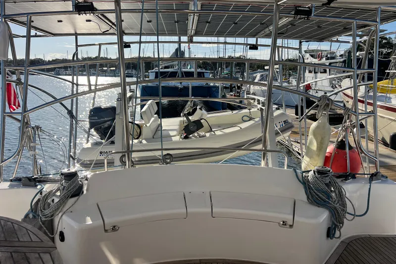 Slide: The Image of Sailboat Privilege 495, 2011 model, docked with solar panels and dinghy in marina. - 18