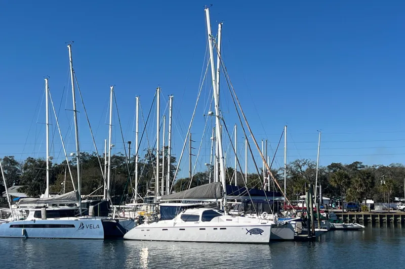 Slide: The Image of Sailboats docked at a marina, featuring a 2011 Privilege 495 catamaran. - 3