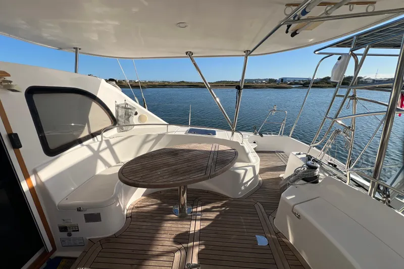 Slide: The Image of Spacious deck of 2011 Privilege 495 yacht with wooden table and seating. - 32