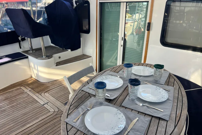 Slide: The Image of Outdoor dining setup on 2011 Privilege 495 yacht with wooden deck and cushioned seating. - 35