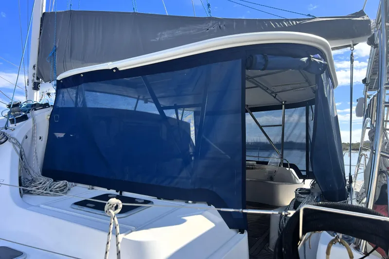 Slide: The Image of Sailing yacht Privilege 495, 2011 model, with blue canopy and ropes, docked by the water. - 36