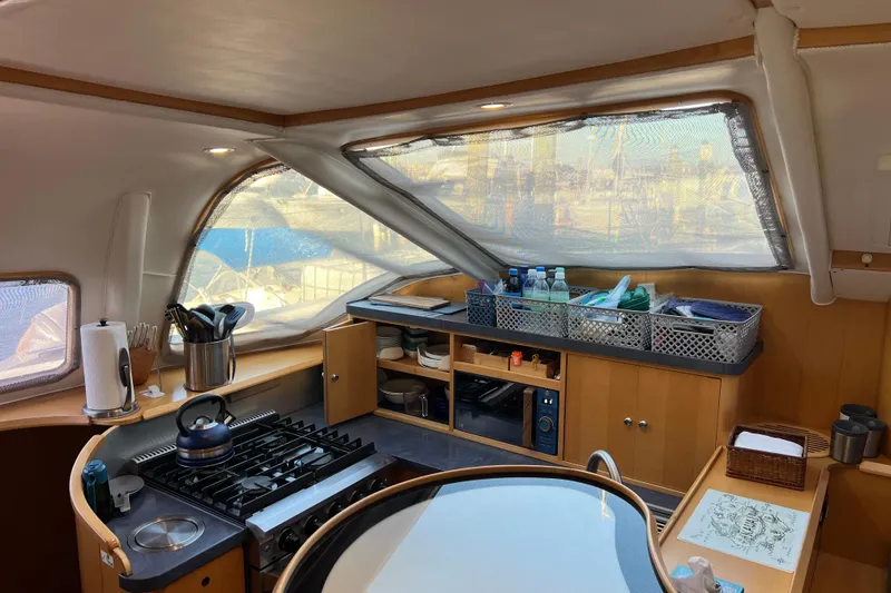 Slide: The Image of Interior of 2011 Privilege 495 yacht kitchen with stove, storage, and window view. - 56