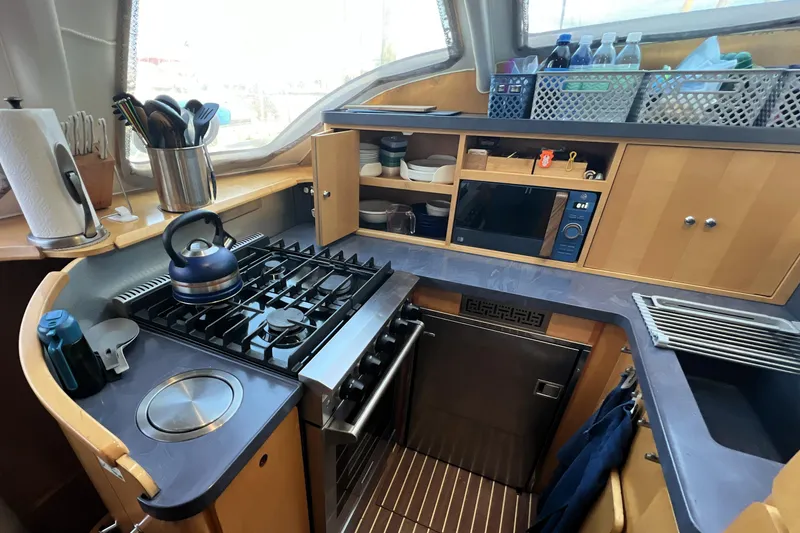 Slide: The Image of Compact kitchen in 2011 Privilege 495 yacht with stove, microwave, and storage. - 61