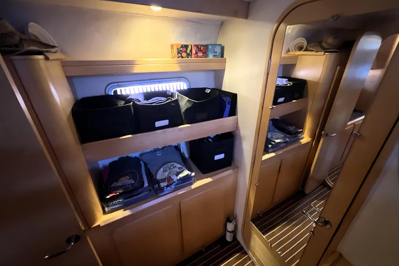 Slide: The Image of Interior of 2011 Privilege 495 yacht with organized storage shelves and wooden finish. - 90