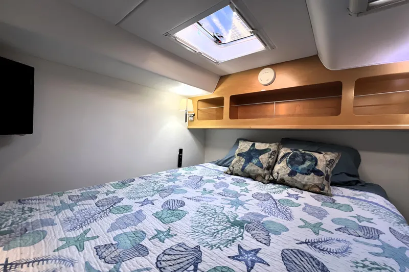 Slide: The Image of Cozy cabin bedroom in 2011 Privilege 495 yacht with nautical-themed bedding and skylight. - 97