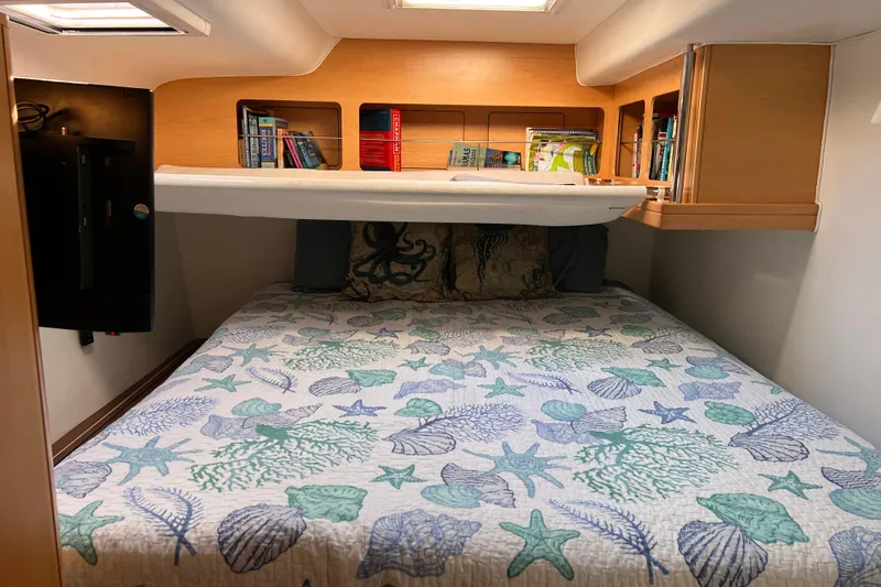 Slide: The Image of Cozy cabin bedroom in 2011 Privilege 495 yacht with nautical-themed bedding and bookshelf. - 98