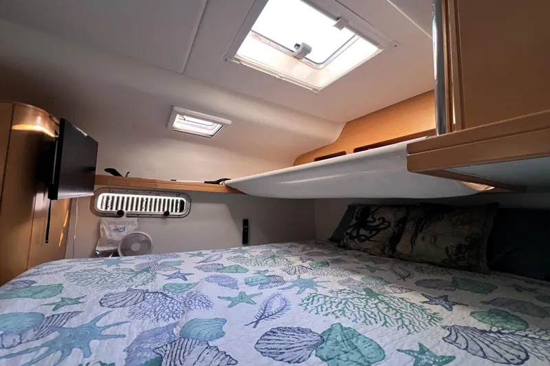 Slide: The Image of Cozy cabin interior of 2011 Privilege 495 yacht with skylight and marine-themed bedding. - 99